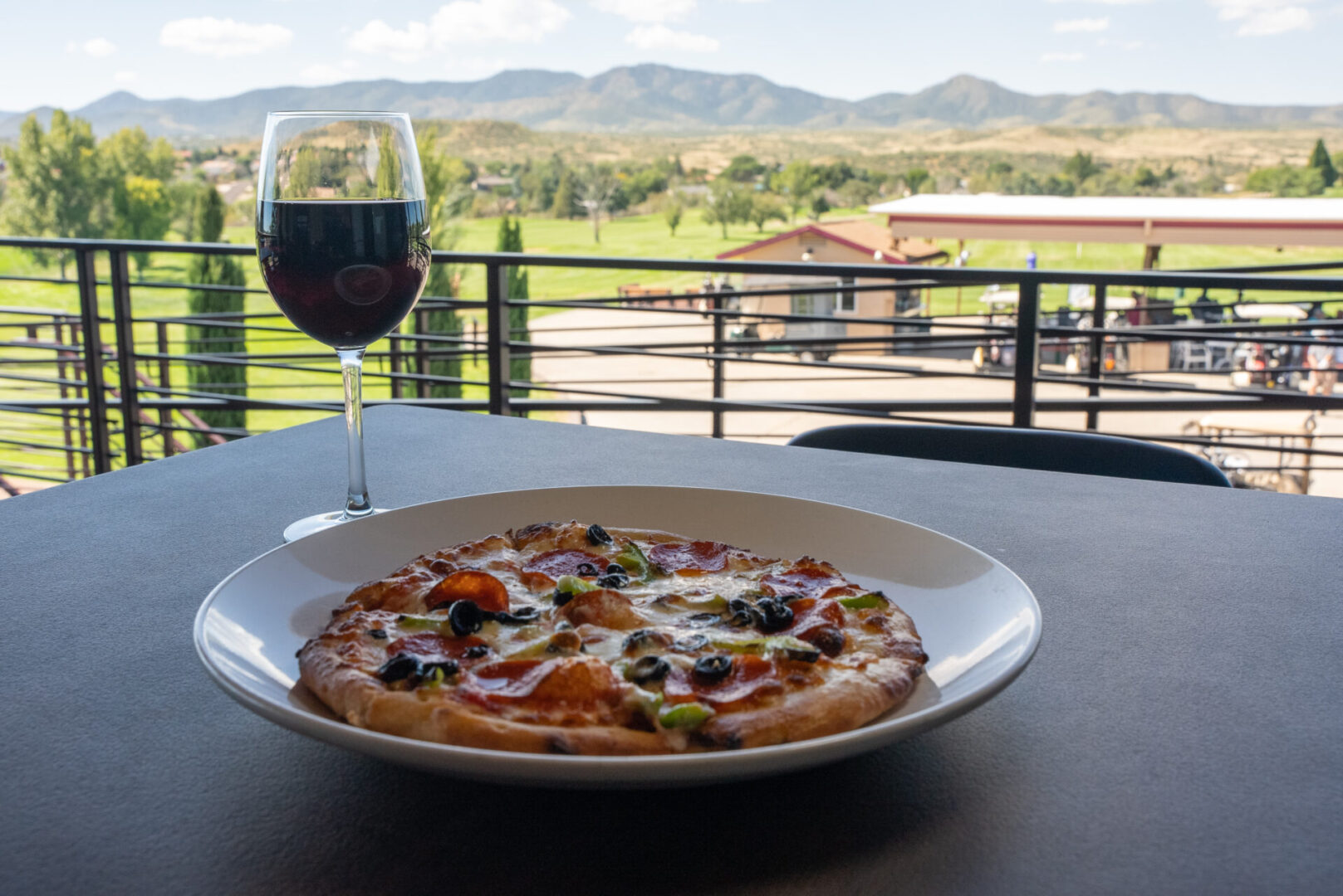 pizza and wine on a table overlooking the golf course