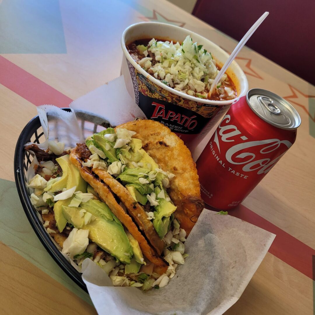 photo of tacos, birria noodles, and a soda