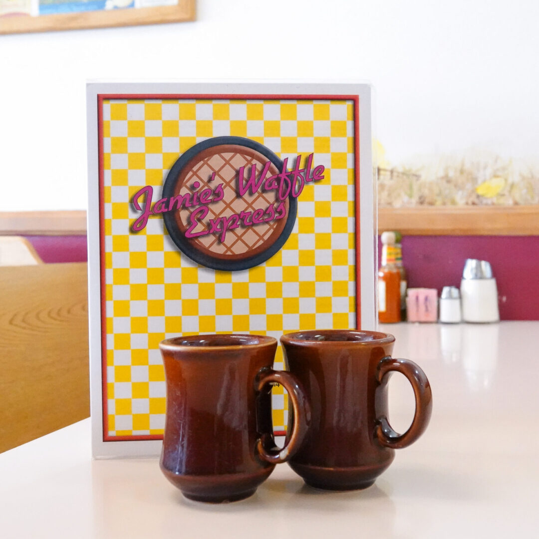 Jamie's Waffle Express menu on table with two coffee mugs