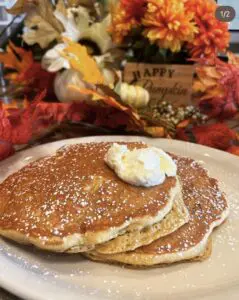 pumpkin pancakes on plate with autumn leaves in background