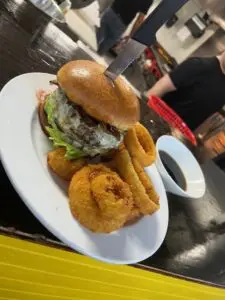 Specialty burger with side of onion rings