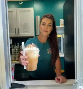 Smile woman holding a cold coffee drink with whipped cream